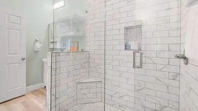 a bathroom with a shower with a glass door at Lemon Drop House in Seacrest