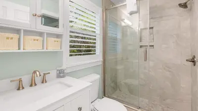 a bathroom with a shower and a toilet and a sink at Lemon Drop House in Seacrest
