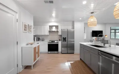 a kitchen with white cabinets and stainless steel appliances at LakeTide Retreat in Santa Rosa Beach