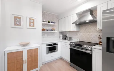 a kitchen with white cabinets and black appliances at LakeTide Retreat in Santa Rosa Beach