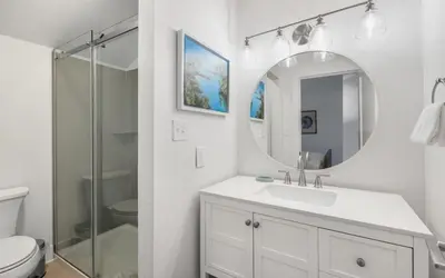 a white bathroom with a sink and a mirror at LakeTide Retreat in Santa Rosa Beach