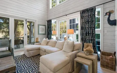 a living room with a couch and a room with windows at Maison Moon in Santa Rosa Beach