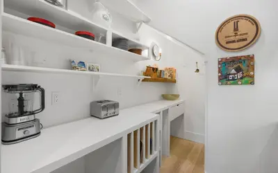 a kitchen with white shelves and a coffee maker on the counter at Maison Moon in Santa Rosa Beach