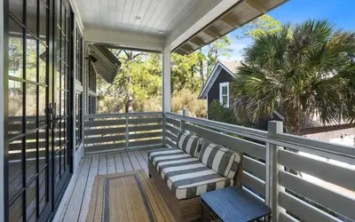 a porch with a bench and a window at Maison Moon in Santa Rosa Beach