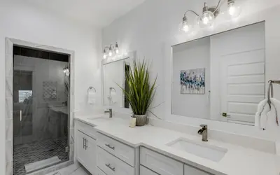 a white bathroom with two sinks and a large mirror at Occasionally Luxe in Seacrest