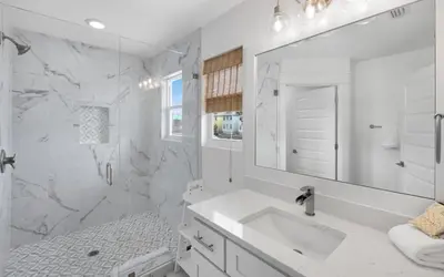 a white bathroom with a sink and a mirror at Occasionally Luxe in Seacrest