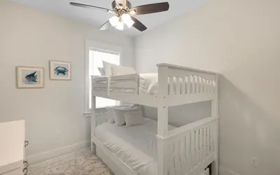 a white bedroom with two bunk beds and a ceiling fan at Once Upon A Tide in Inlet Beach