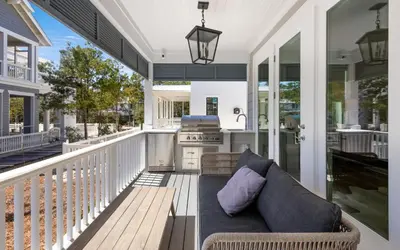 a screened in porch with a couch and a stove at Out of Office in Santa Rosa Beach