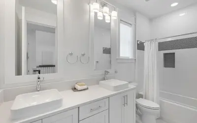 a white bathroom with two sinks and a toilet at Out of Office in Santa Rosa Beach