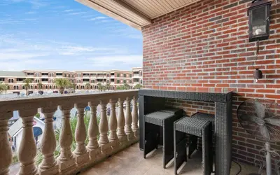 a balcony with a fireplace and a brick wall at Peanuts Place in Seacrest