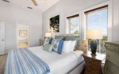 a bedroom with a bed with blue and white pillows at Peanuts Place in Seacrest