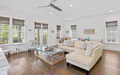 a living room with a couch and a table at Pirates Smile in Rosemary Beach
