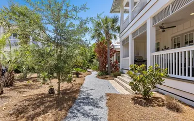 a walkway in front of a house with trees at Pirates Smile in Rosemary Beach