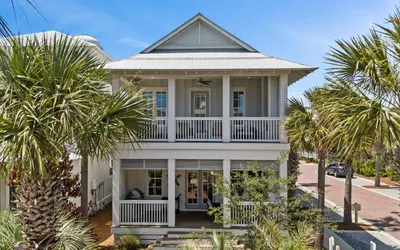 a house with palm trees in front of it at Pirates Smile in Rosemary Beach