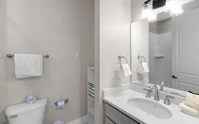 a white bathroom with a sink and a mirror at Saltwater Song in Santa Rosa Beach