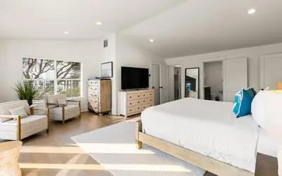 a bedroom with a white bed and a television at Sea n Stars in Seacrest
