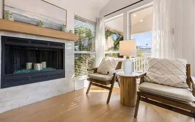 a living room with a fireplace and a chair at Sea n Stars in Seacrest