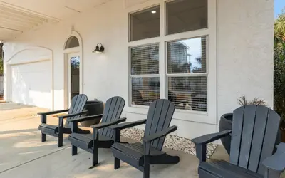 four chairs sitting on the porch of a house at Sea n Stars in Seacrest