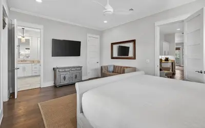a white bedroom with a large bed and a television at Sundance in Inlet Beach