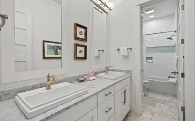 a white bathroom with two sinks and a shower at Sundance in Inlet Beach