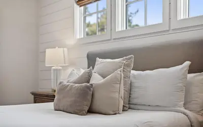 a pile of pillows on a bed with windows at Sundance in Inlet Beach