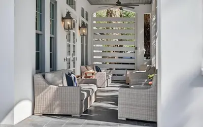 a porch with wicker chairs and a table at Sundance in Inlet Beach