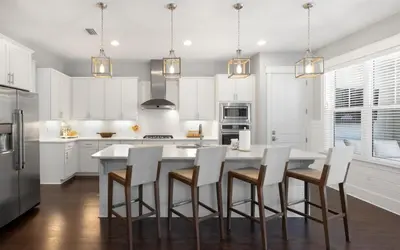 a kitchen with white cabinets and a white table and chairs at Surf Sanctuary in Santa Rosa Beach