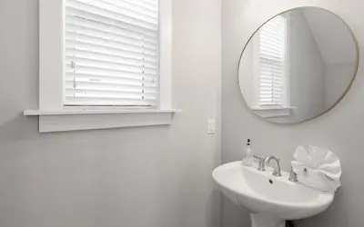 a white bathroom with a mirror and a sink at Surf Sanctuary in Santa Rosa Beach
