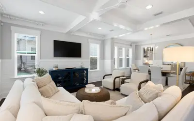 a living room with a white couch and a dining room at Surf Sanctuary in Santa Rosa Beach