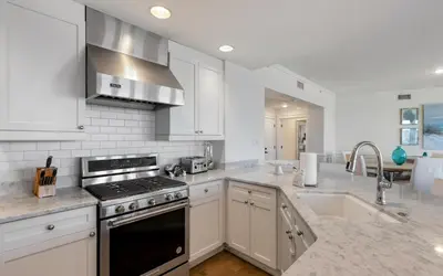 a kitchen with white cabinets and a stove top oven at The Crossings at Watersound Beach C214 in Inlet Beach
