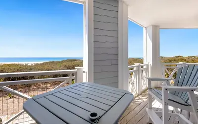 a porch with two chairs and the ocean at The Crossings at Watersound Beach C214 in Inlet Beach