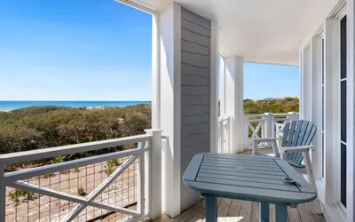 a blue bench on a porch with a view of the ocean at The Crossings at Watersound Beach C214 in Inlet Beach