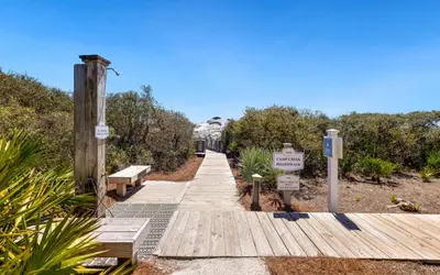 a wooden boardwalk with benches and a sign on it at The Crossings at Watersound Beach C214 in Inlet Beach