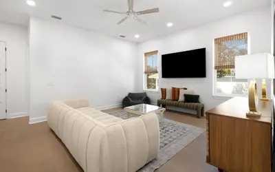 a living room with a couch and a flat screen tv at Tickled Pink in Santa Rosa Beach