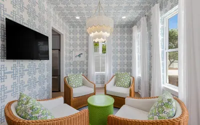 a living room with chairs and a tv at Tickled Pink in Santa Rosa Beach