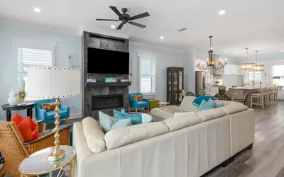 a living room with a white couch and a fireplace at Villa Dolce in Santa Rosa Beach