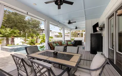 a screened in porch with a table and chairs at Villa Dolce in Santa Rosa Beach