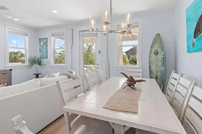 a white dining room with a table and chairs at Sea Turtle House- Lux Townhome- Pool - Golf Cart in Santa Rosa Beach