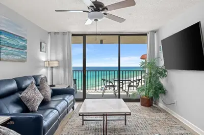a living room with a couch and a ceiling fan at Breathtaking Sunset View Beachfront Condo Resort in Panama City Beach