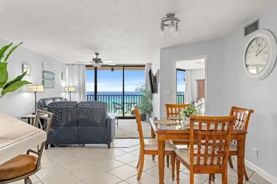 a dining room and living room with a table and chairs at Breathtaking Sunset View Beachfront Condo Resort in Panama City Beach