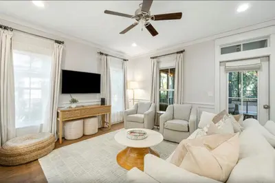 a living room with a white couch and a tv at Sleeps 18 | Bikes | Sunshine State of Mind | 30A | Pool | Beach Access in Inlet Beach