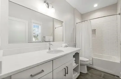 a bathroom with a sink and a toilet and a mirror at Sleeps 18 | Bikes | Sunshine State of Mind | 30A | Pool | Beach Access in Inlet Beach