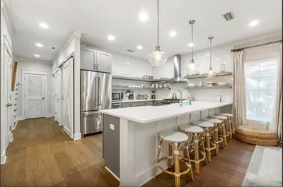 a kitchen with a large island with bar stools at Sleeps 18 | Bikes | Sunshine State of Mind | 30A | Pool | Beach Access in Inlet Beach