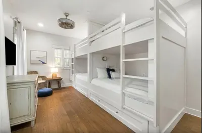 a bedroom with white bunk beds and a desk at Sleeps 18 | Bikes | Sunshine State of Mind | 30A | Pool | Beach Access in Inlet Beach
