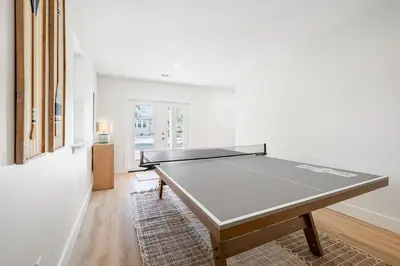 a ping pong table in the middle of a room at Backyard Oasis ,Pool, Sandy Magnolia, Sleeps 16,Eastern Lake, Golf Cart,Bikes in Santa Rosa Beach