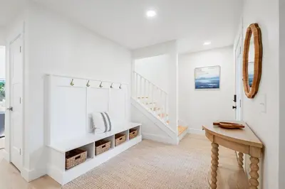 a white room with a staircase and a table at Backyard Oasis ,Pool, Sandy Magnolia, Sleeps 16,Eastern Lake, Golf Cart,Bikes in Santa Rosa Beach