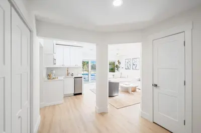 a white room with a kitchen and a living room at Backyard Oasis ,Pool, Sandy Magnolia, Sleeps 16,Eastern Lake, Golf Cart,Bikes in Santa Rosa Beach