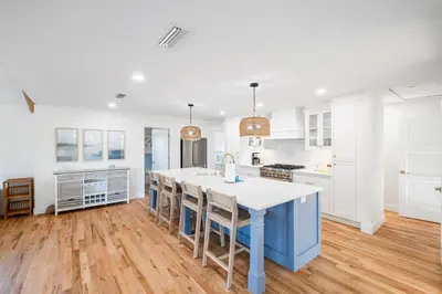 a kitchen with a blue island and white cabinets at Backyard Oasis ,Pool, Sandy Magnolia, Sleeps 16,Eastern Lake, Golf Cart,Bikes in Santa Rosa Beach