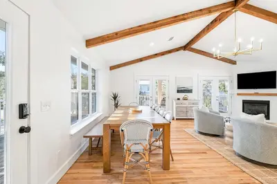 a dining room and living room with a wooden table and chairs at Backyard Oasis ,Pool, Sandy Magnolia, Sleeps 16,Eastern Lake, Golf Cart,Bikes in Santa Rosa Beach