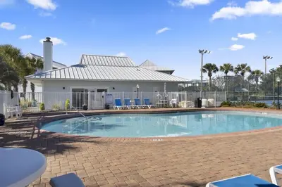 a swimming pool with chairs and a house at You are my Sunshine- Heated Pool- Steps to sand in Santa Rosa Beach